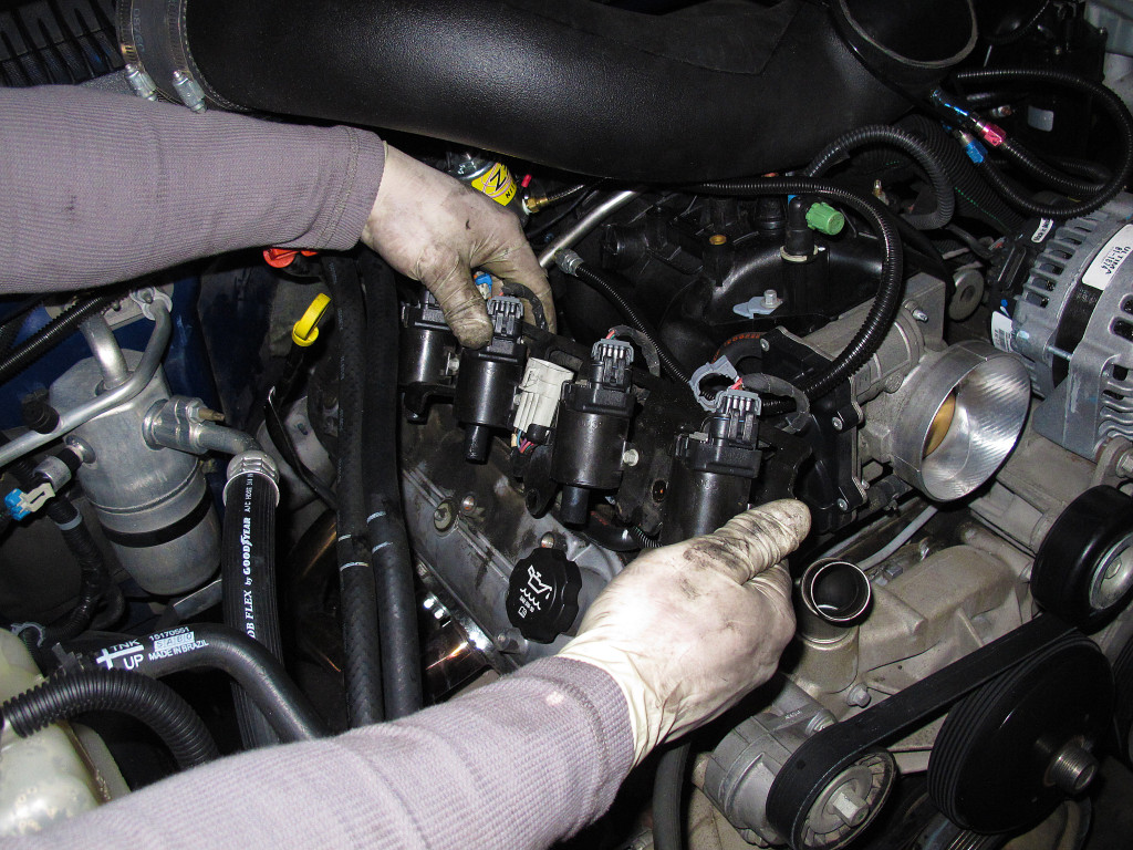 Next the spark plug wires are disconnected along with the harness for the coils, then the ignition coil assembly is unbolted from the valvecovers so they can be removed.